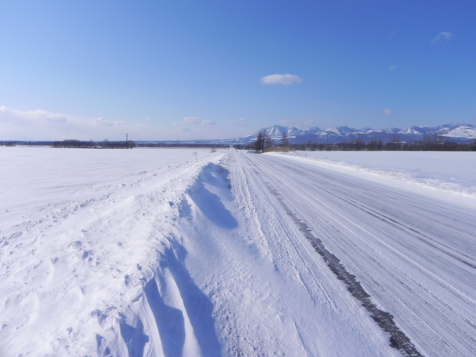 A packed-snow road through winter fields in Shihoro, Hokkaido